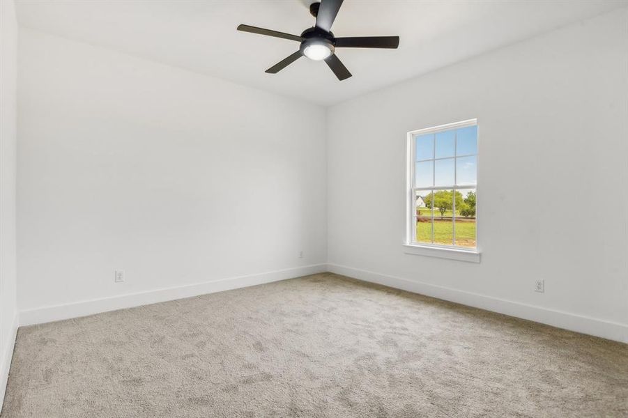 Empty room featuring light carpet and a ceiling fan Empty room featuring light carpet and a ceiling fan