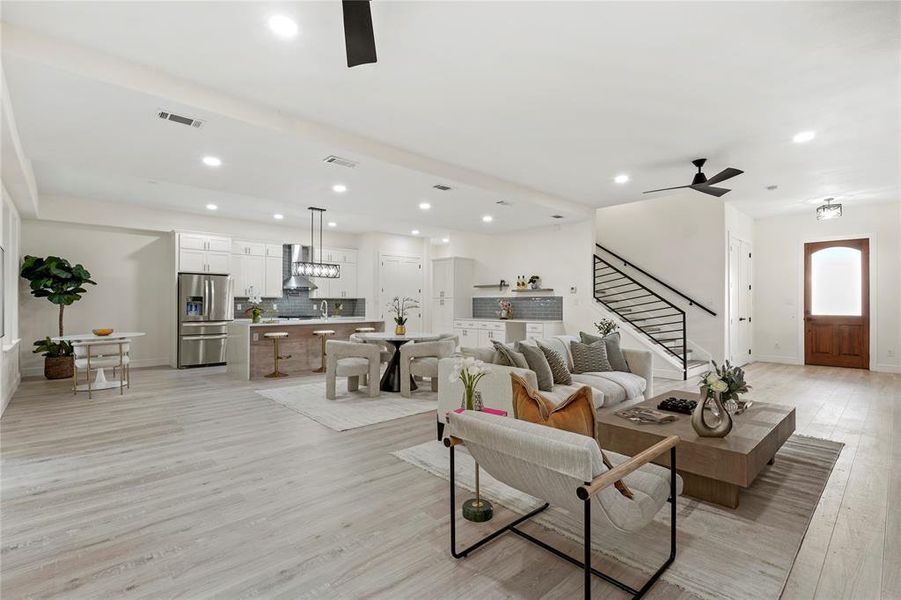 Living area with a ceiling fan, light wood-style flooring, stairs, and recessed lighting Living area with a ceiling fan, light wood-style flooring, stairs, and recessed lighting