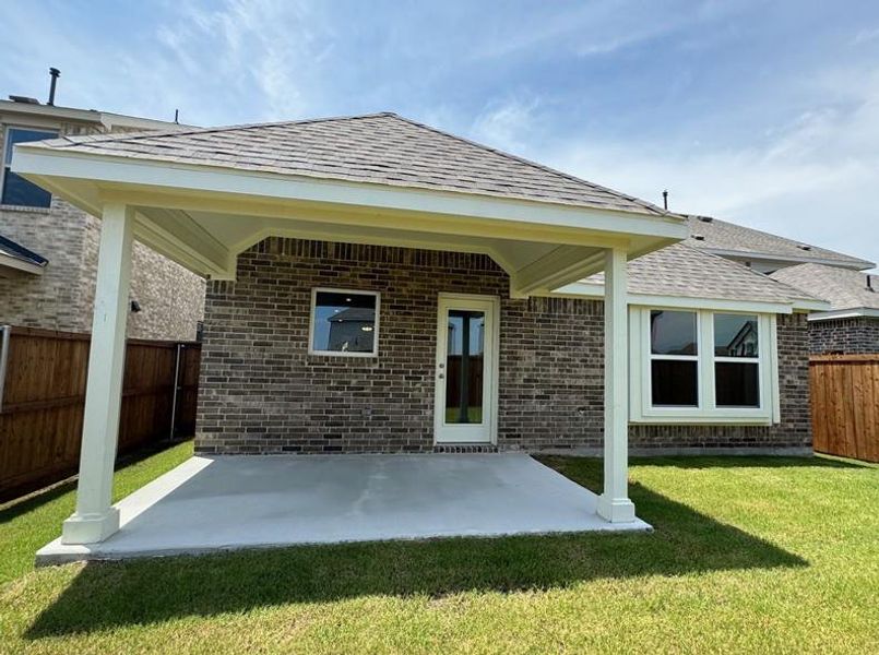 Rear view of property with brick siding, a fenced backyard, a shingled roof, and a patio area Rear view of property with brick siding, a fenced backyard, a shingled roof, and a patio area