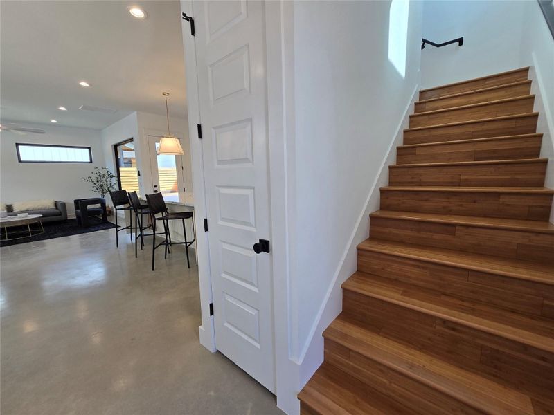 Stairs featuring recessed lighting, ceiling fan, and concrete floors Stairs featuring recessed lighting, ceiling fan, and concrete floors