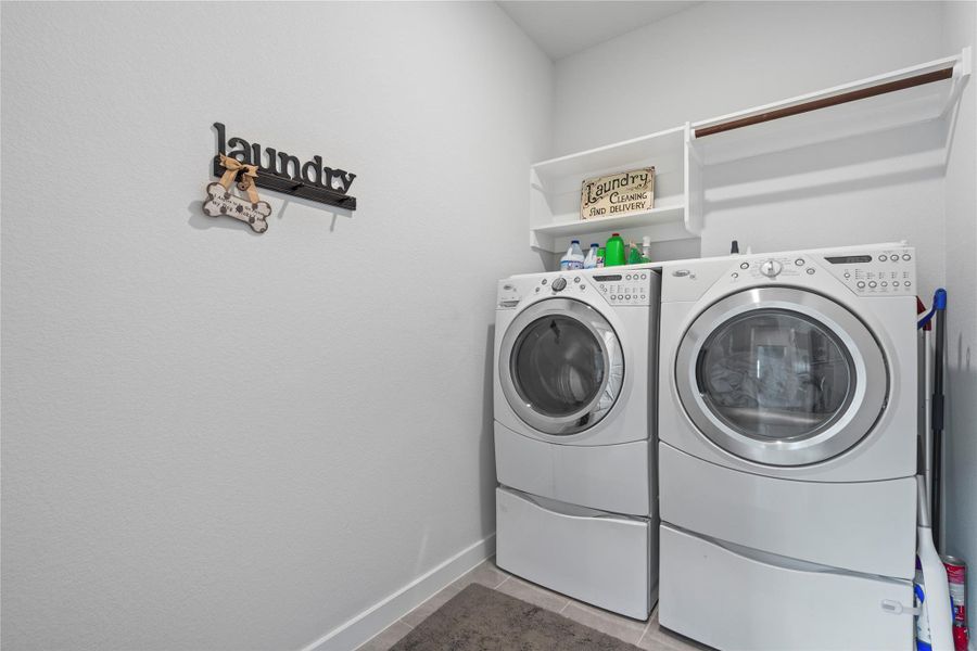 Laundry area featuring independent washer and dryer, baseboards, and tile patterned floors Laundry area featuring independent washer and dryer, baseboards, and tile patterned floors