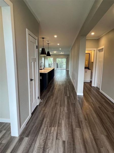Hallway with dark wood-type flooring and recessed lighting