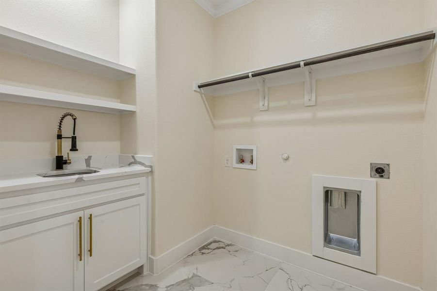 Laundry room with hookup for a gas dryer, hookup for a washing machine, ornamental molding, light marble finish floors, and electric dryer hookup