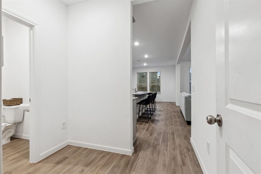 This is the view of the spacious mud area as you enter through the garage. Imagine all the storage options here! To the right is a huge under-stair storage closet and to the left is a large half bathroom perfect for your guests.