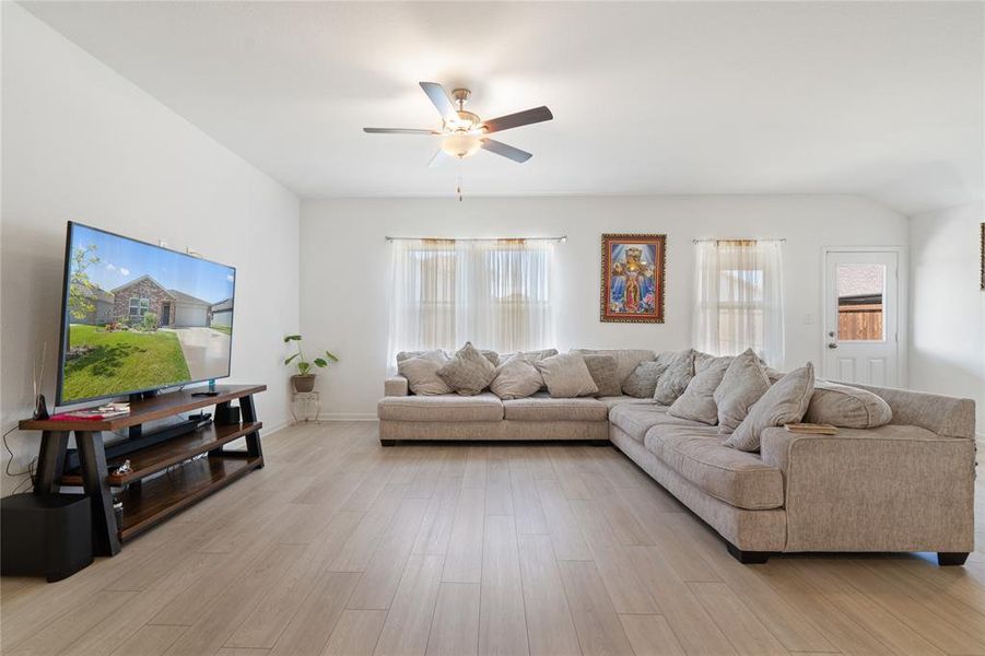 Living area featuring plenty of natural light, light wood-style floors, and a ceiling fan