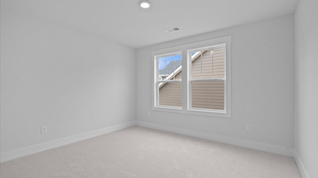 Superior comfort in this light-filled bedroom with plush carpeting and thoughtfully placed large windows