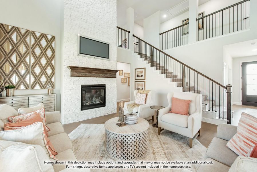 Living room with two-story ceiling, white stone fireplace, staircase, and neutral seating area Living room with two-story ceiling, white stone fireplace, staircase, and neutral seating area