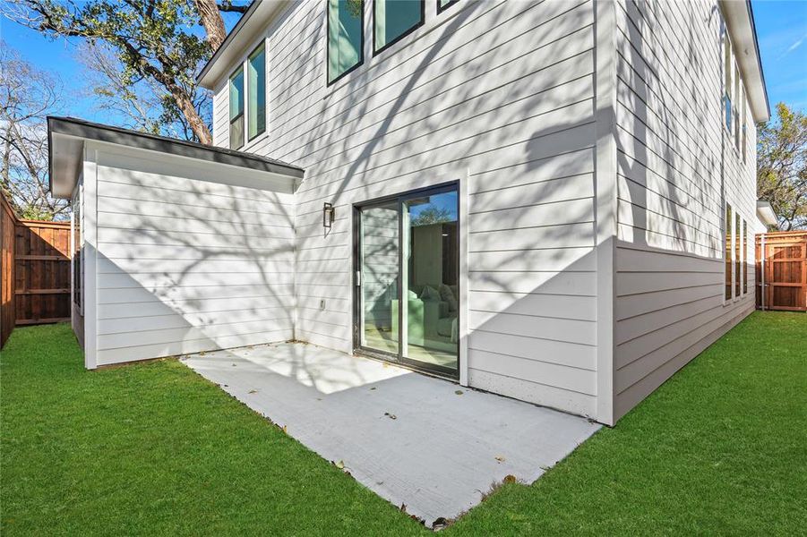 Rear view of house featuring a fenced backyard and a patio