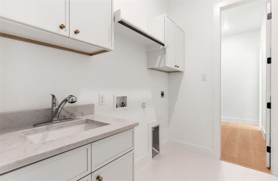 Laundry area with cabinet space, washer hookup, electric dryer hookup, gas dryer hookup, and light tile patterned floors
