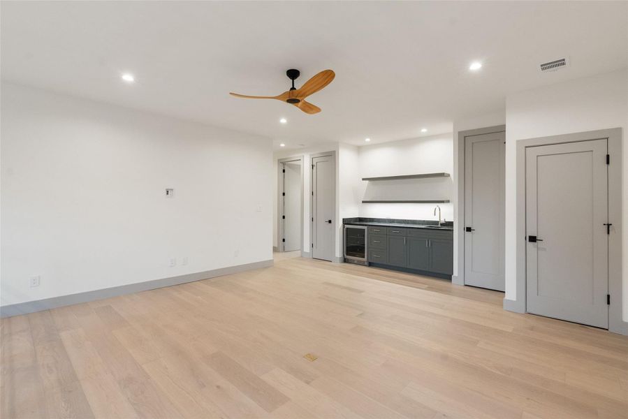 Gameroom or playroom with wet bar.