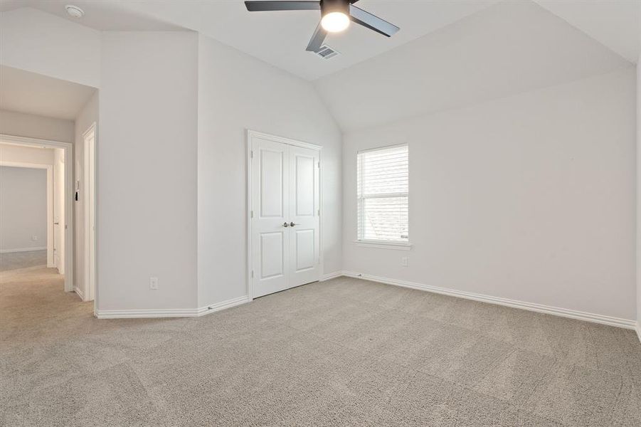 Secondary bedroom featuring vaulted ceiling and an ensuite bathroom