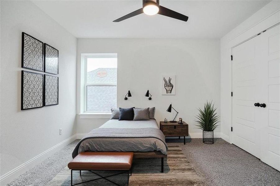 Carpeted bedroom featuring a ceiling fan and a closet
