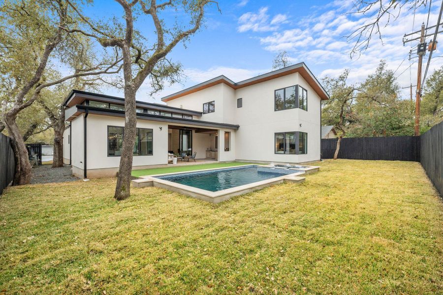 Rear view of property featuring a fenced backyard, stucco siding, and a patio