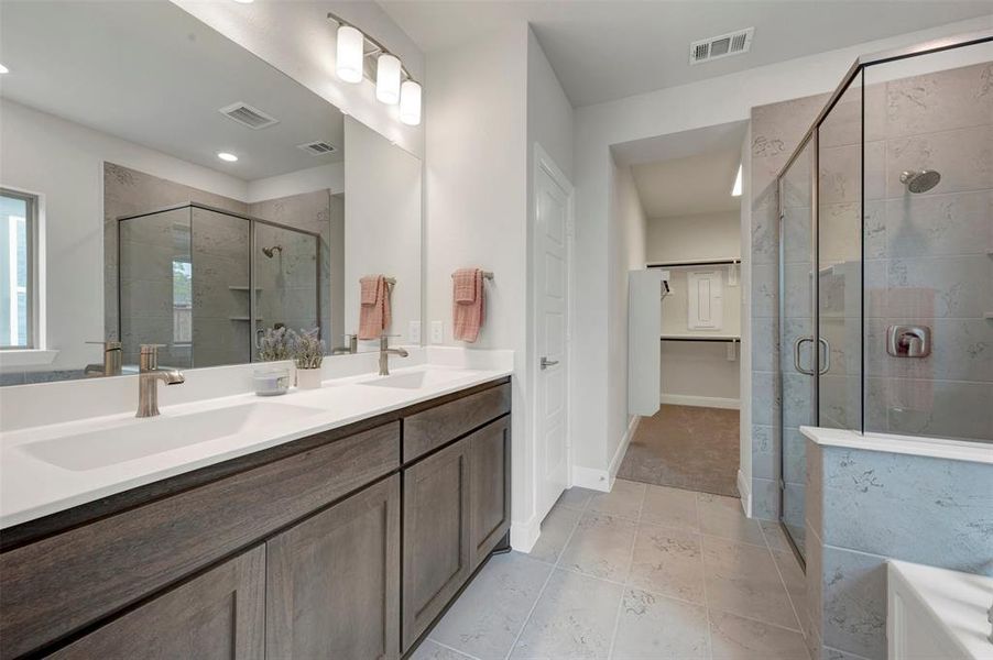 Dual vanity with white undermount sinks, bronze faucets, and dark wood-finish cabinetry