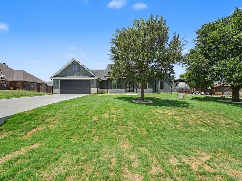 Contemporary home with a dark green exterior, board and batten siding, and an attached two-car garage Contemporary home with a dark green exterior, board and batten siding, and an attached two-car garage