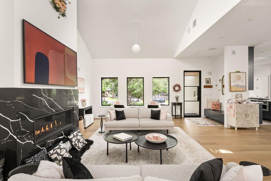 An inviting living room features a striking black marble fireplace and warm hardwood floors. An inviting living room features a striking black marble fireplace and warm hardwood floors.