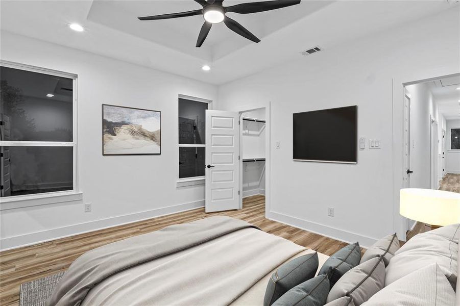 Bedroom featuring a closet, light hardwood / wood-style floors, a spacious closet, and ceiling fan