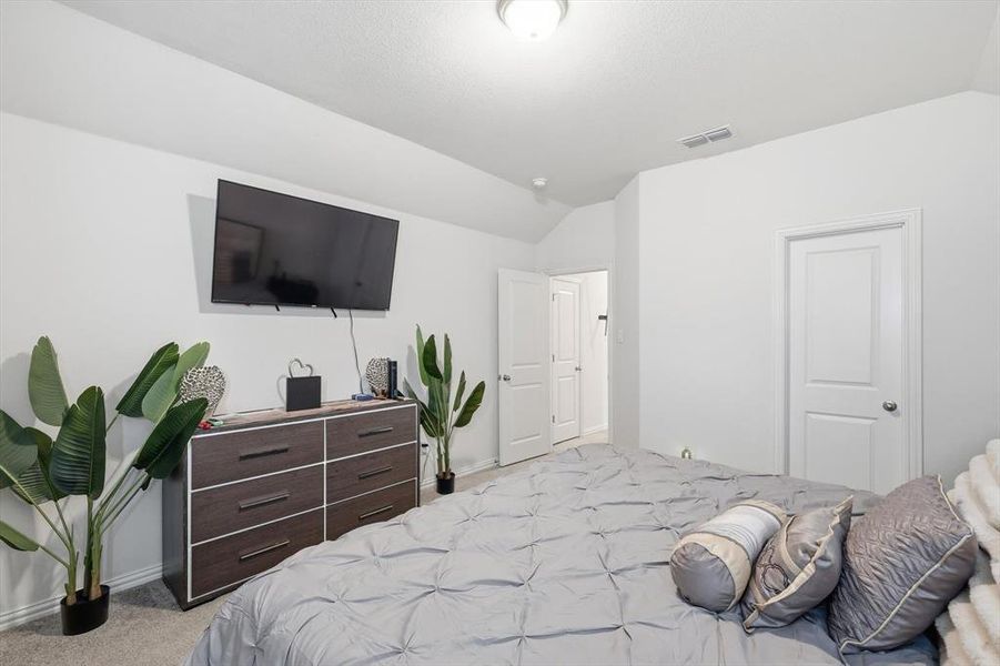 Bedroom featuring lofted ceiling and light colored carpet