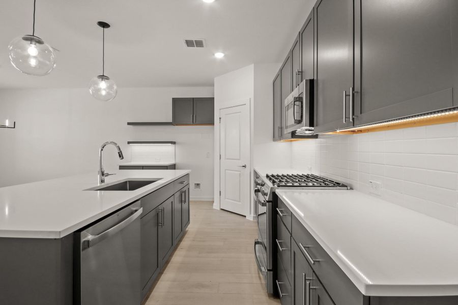 Stunning kitchen with quartz countertops, grey cabinets, and stylish floating shelves Stunning kitchen with quartz countertops, grey cabinets, and stylish floating shelves