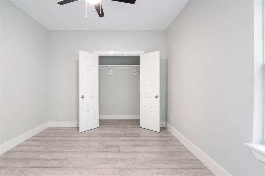 Unfurnished bedroom featuring a closet, ceiling fan, and light hardwood / wood-style flooring