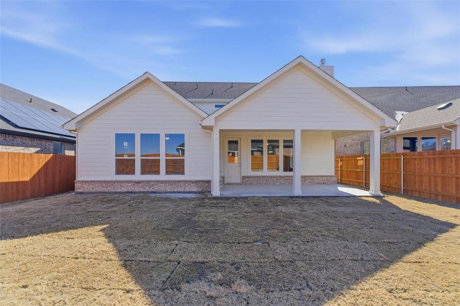 Rear view of property with a patio and a fenced backyard