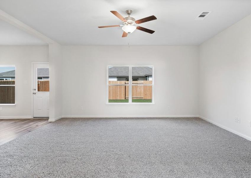 The family room has windows with a view of the fully fenced back yard.