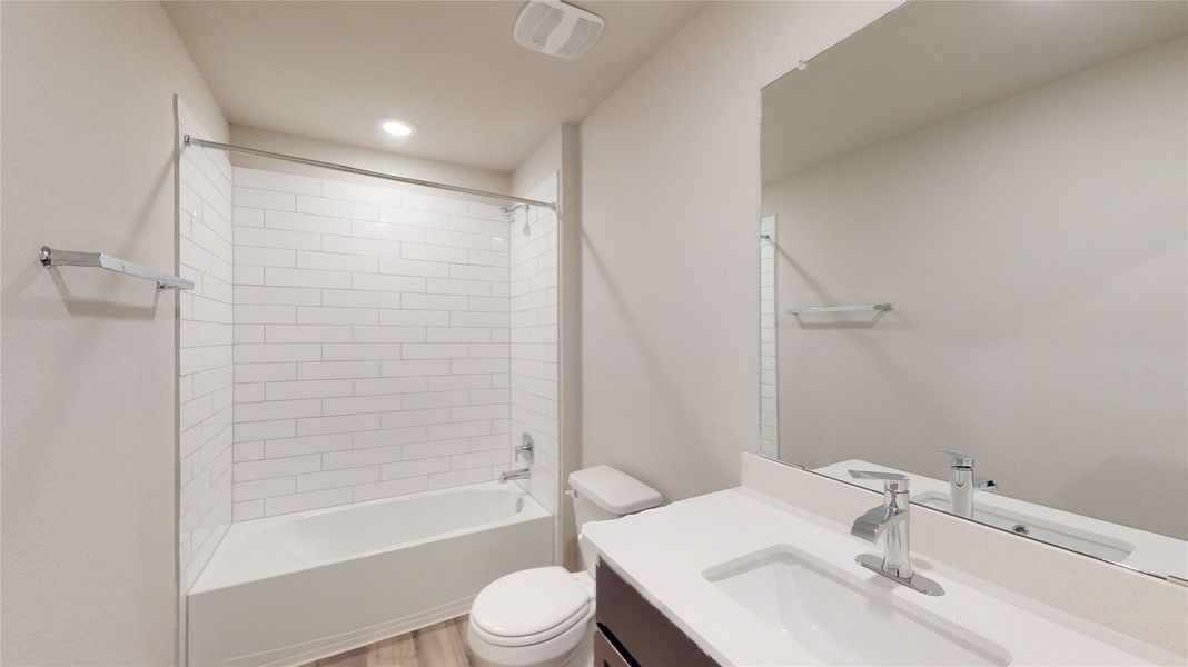 A well-appointed bathroom offers a clean tub-shower combination with subway tile surround and a modern vanity with a large mirror. A well-appointed bathroom offers a clean tub-shower combination with subway tile surround and a modern vanity with a large mirror.