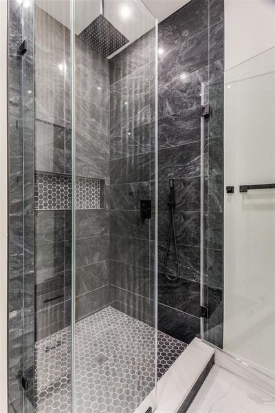 Bathroom featuring marble finish floor and a stall shower