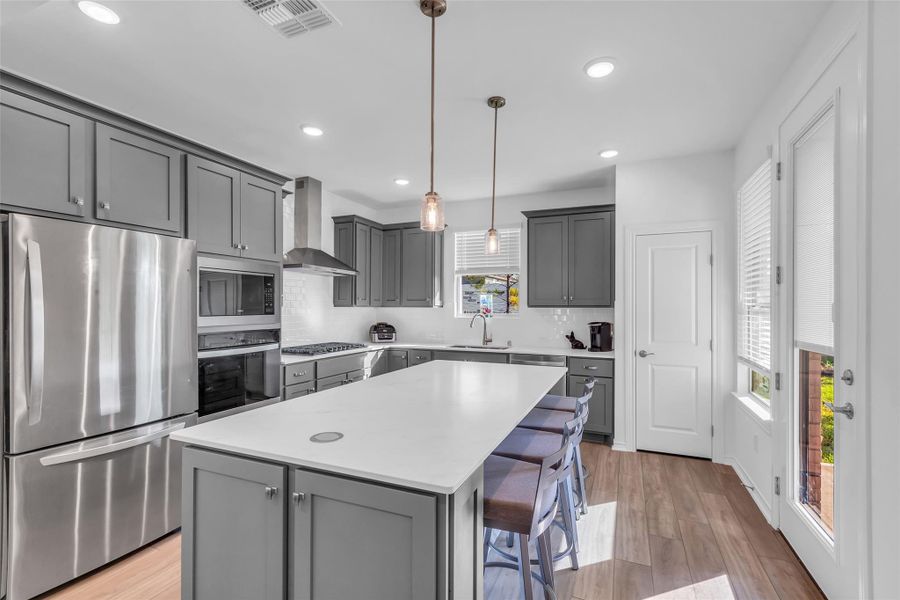 Photos don't do it justice! This kitchen is jaw droppingly gorgeous in person. Everything about it just works so well - the shiny tile, bright countertops, the layout, the positioning of the island and the wall oven and the cooktop and even the sink facing out into the backyard so you can keep an eye on the birds and clouds while you wash your hands.