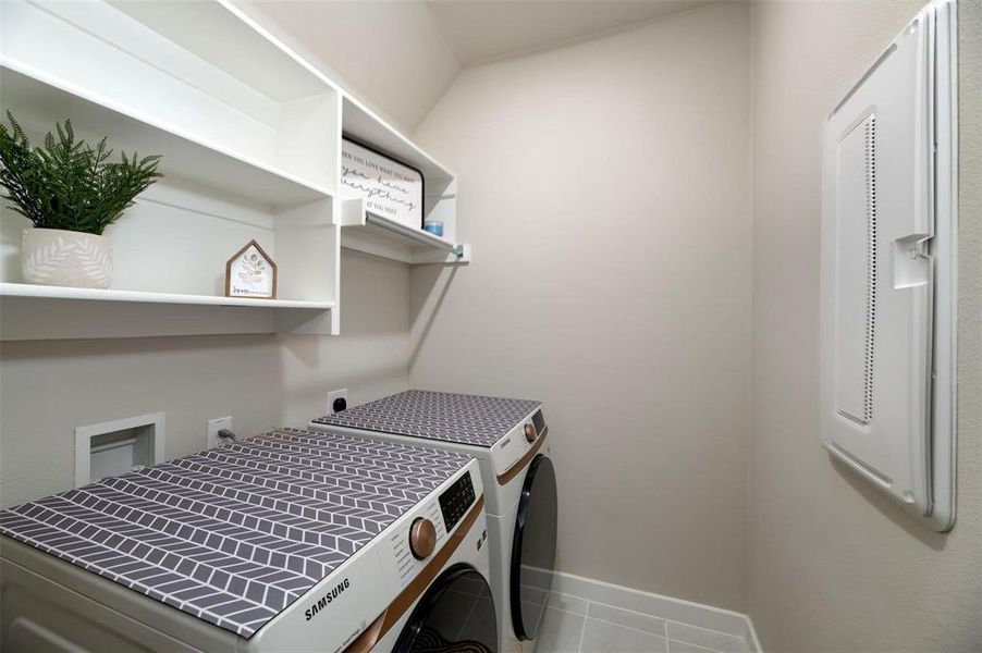 Washroom with light tile patterned floors, hookup for a washing machine, and hookup for an electric dryer Washroom with light tile patterned floors, hookup for a washing machine, and hookup for an electric dryer