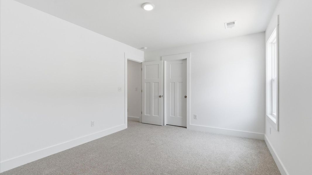 First-class bedroom with generous proportions, a walk-in closet, and beautiful natural light through a large window