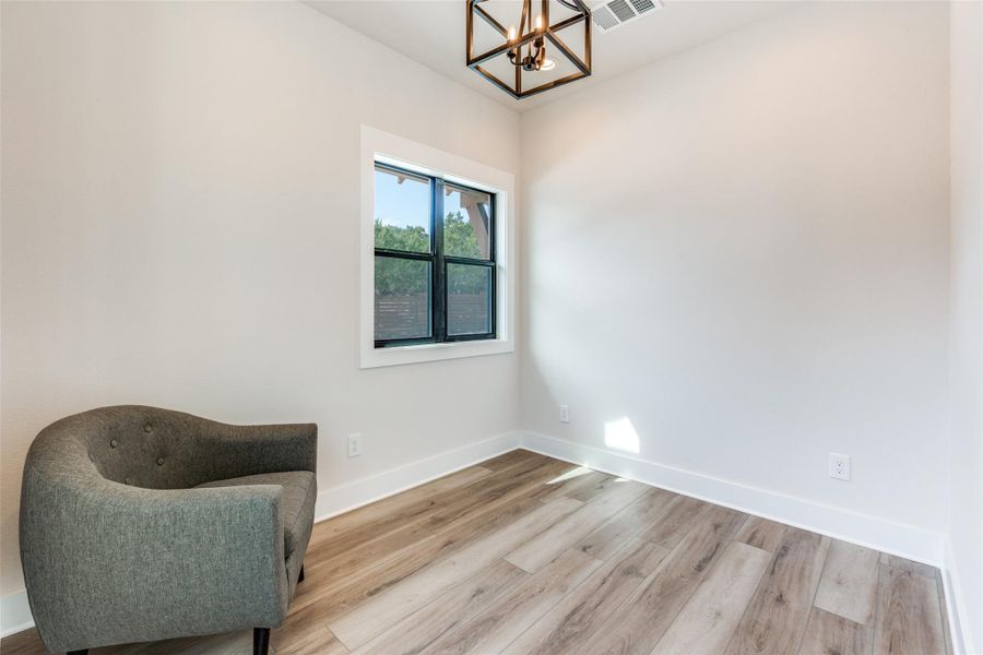 Unfurnished room with hanging lights and light wood-style flooring