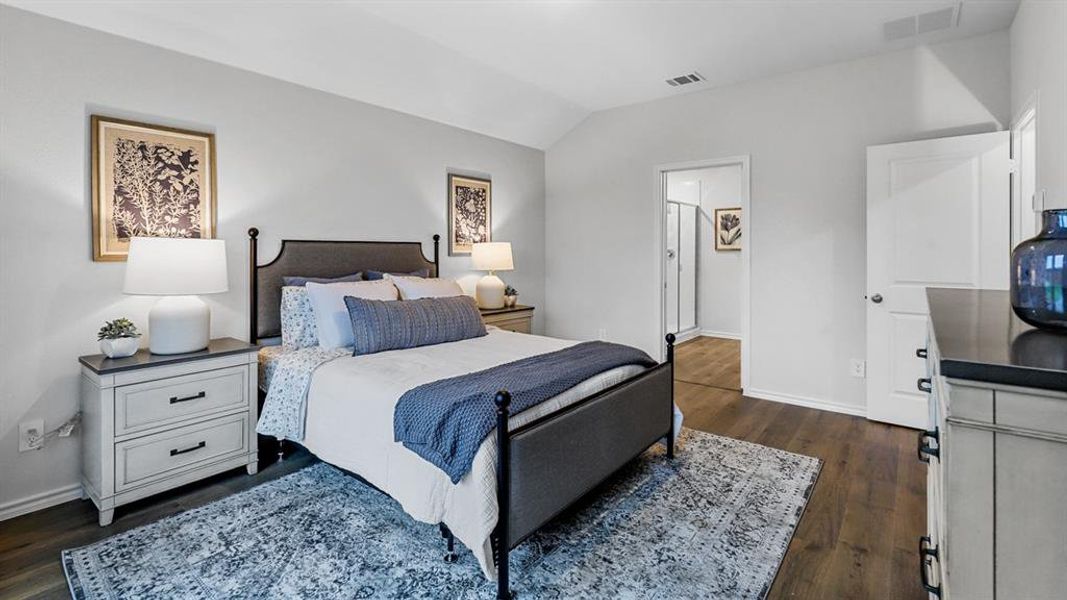 Bedroom featuring dark wood-style flooring and vaulted ceiling Bedroom featuring dark wood-style flooring and vaulted ceiling