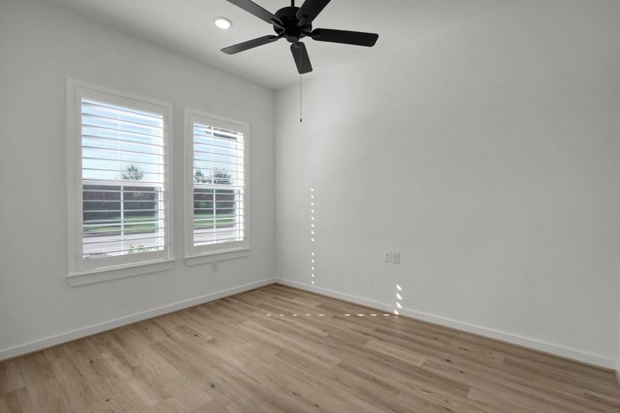 Immediately to the left of the entryway is this space that can be used as a home office or sitting room. There is a ceiling fan and recessed lights plus windows bringing in natural light.