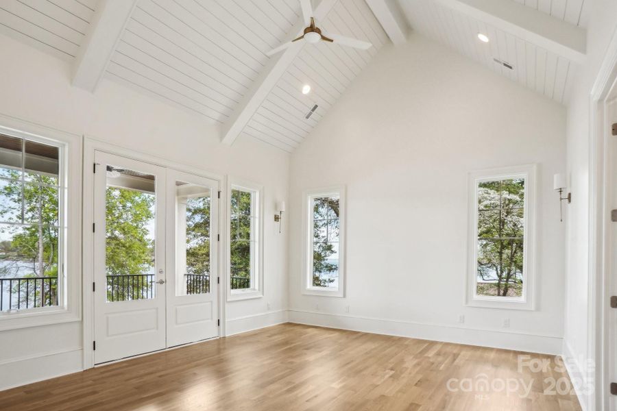 Empty primary bedroom on the main floor with walk out to the back porch