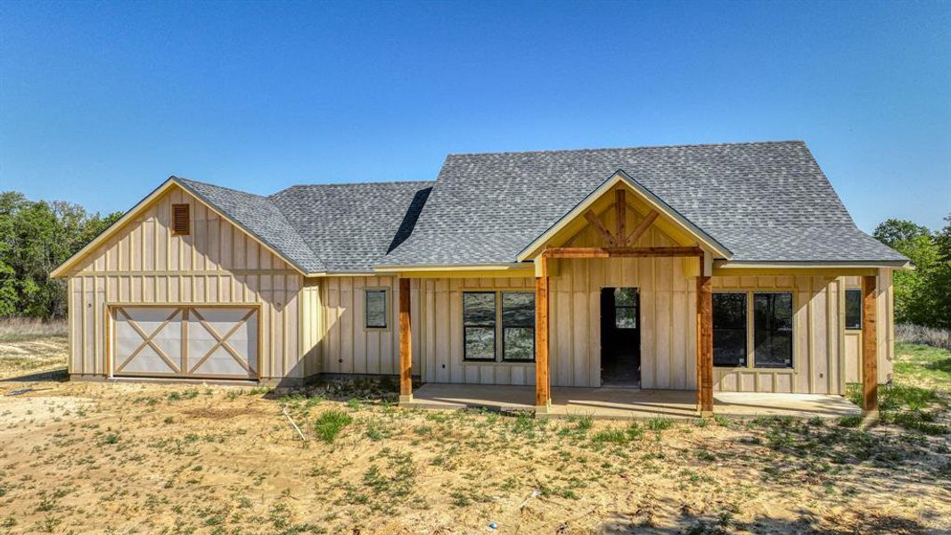 View of front facade featuring board and batten siding, a shingled roof, and an attached garage View of front facade featuring board and batten siding, a shingled roof, and an attached garage