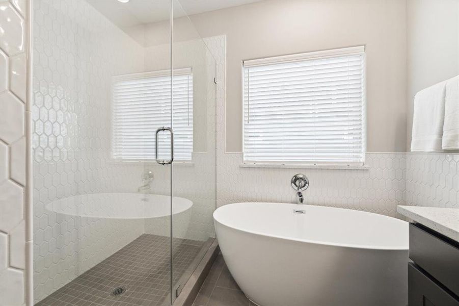 The frameless glass shower enclosure adds a sleek, modern touch, while the 5' soaking tub invites you to unwind in style.