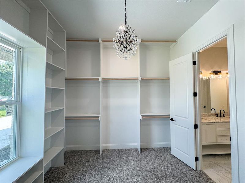 Walk in closet featuring a chandelier Walk in closet featuring a chandelier