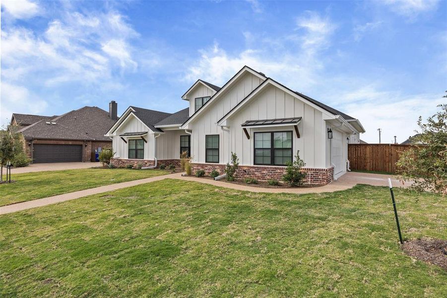Modern farmhouse featuring board and batten siding and a garage Modern farmhouse featuring board and batten siding and a garage