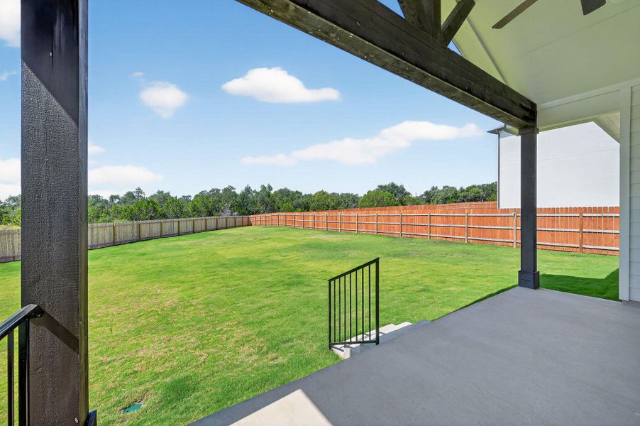 Fenced backyard featuring a patio area and a ceiling fan