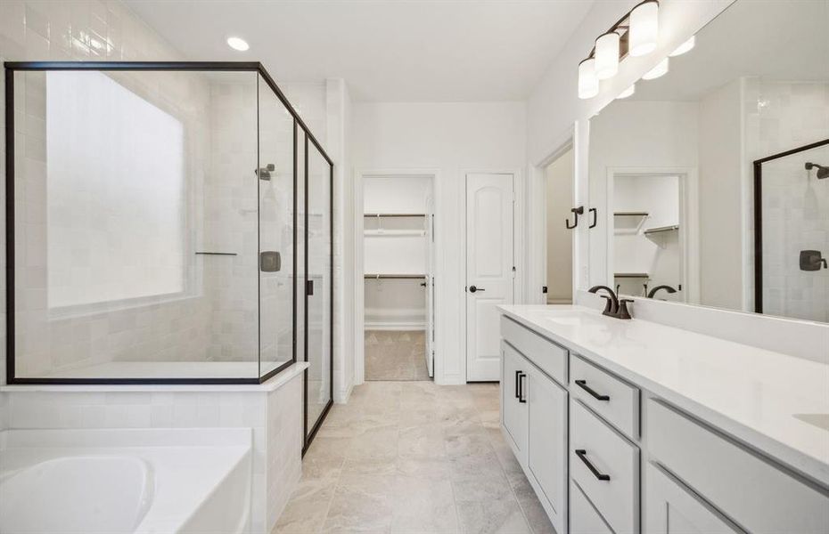 Elegant owner's bathroom with dual vanity and oversized shower *real home pictured