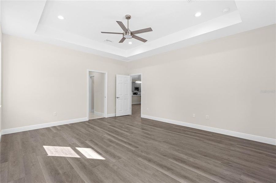 PRIMARY SUITE BEDROOM WITH CEILING FAN, PLENTY OF LIGHTING AND TRAY CEILING