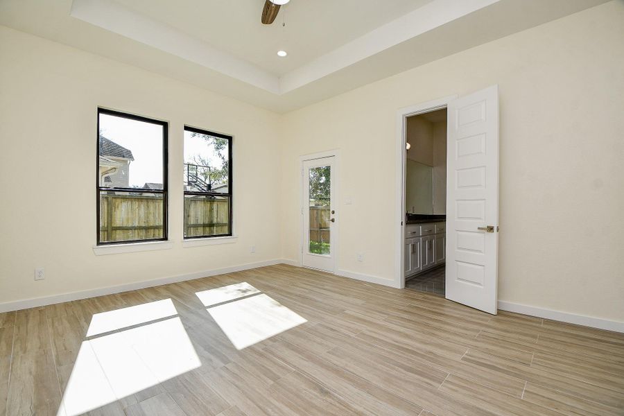 Retreat in this gracious Primary Suite that boasts tall windows and soaring tray-ceilings. This sanctuary is located on the first floor for addition comfort and privacy. Retreat in this gracious Primary Suite that boasts tall windows and soaring tray-ceilings. This sanctuary is located on the first floor for addition comfort and privacy.