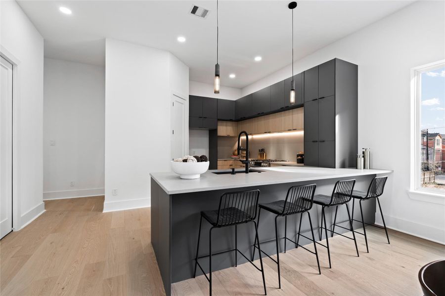 Symmetry meets sophistication in this stunning culinary centerpiece. This stunning island serves as both functional workspace and refined gathering point, flanked by a wall of custom cabinetry that reads like art. Every element—from the minimalist pendant lighting to the integrated appliance space—is a nod to intentional design, where form follows function, andeveryday moments feel beautifully elevated.