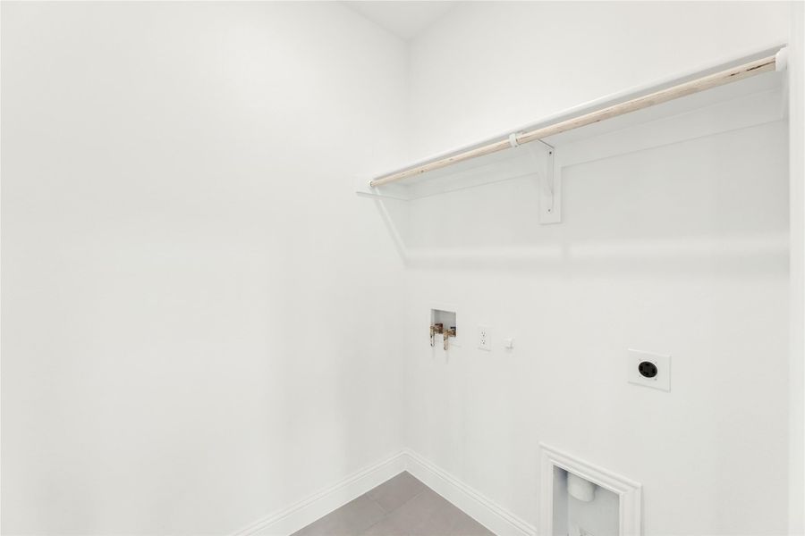 Empty laundry room with white walls, upper shelf, washer hookups, and dryer vent connection Empty laundry room with white walls, upper shelf, washer hookups, and dryer vent connection