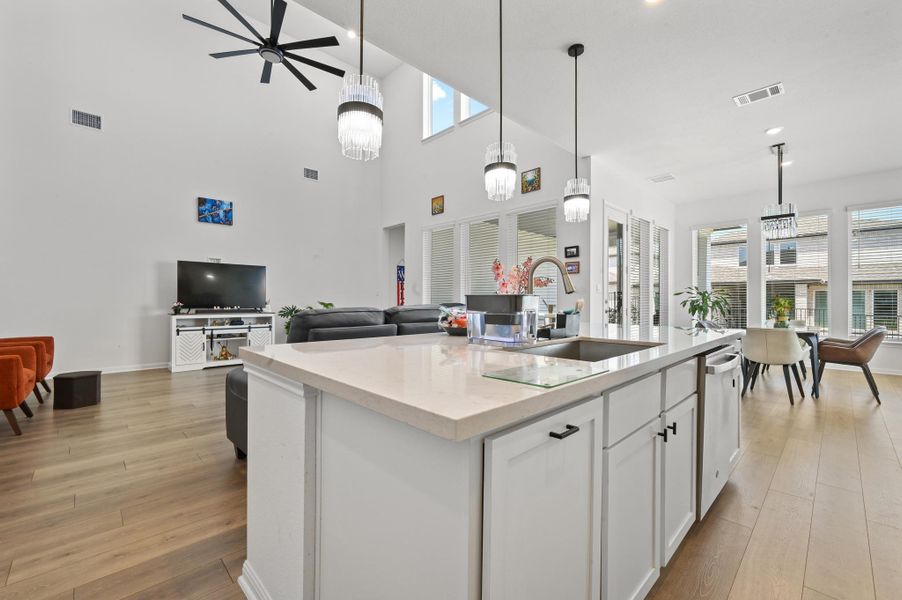 Soaring ceilings and warm wood floors anchor this seamless open-concept main living space.
