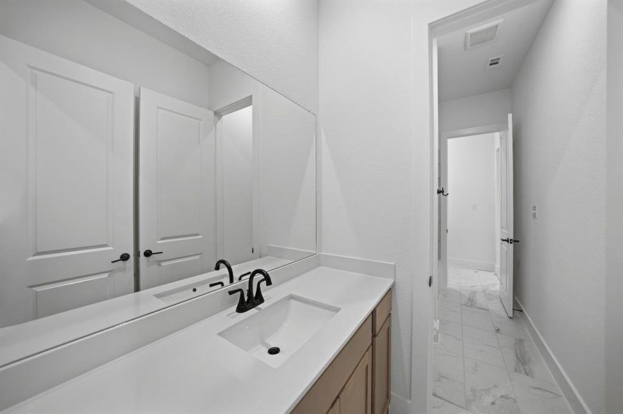 Bathroom featuring light marble finish flooring and vanity Bathroom featuring light marble finish flooring and vanity