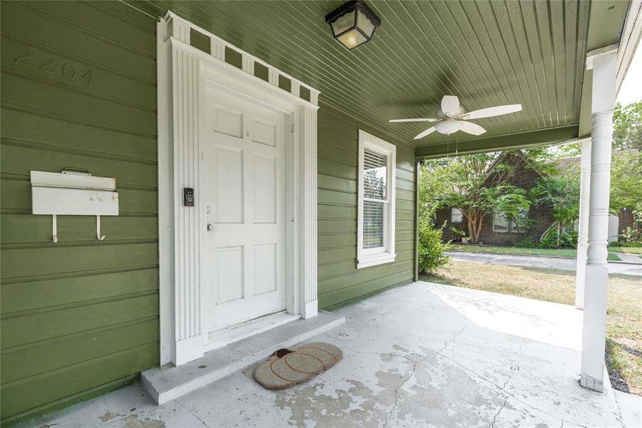 Doorway to property with covered porch and a ceiling fan Doorway to property with covered porch and a ceiling fan