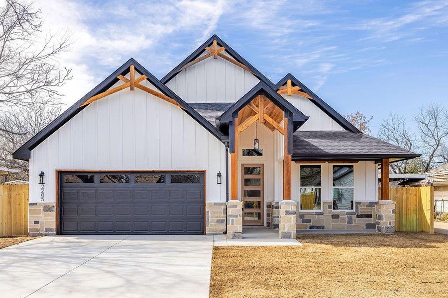 Modern farmhouse style home featuring a garage, fence, concrete driveway, and roof with shingles