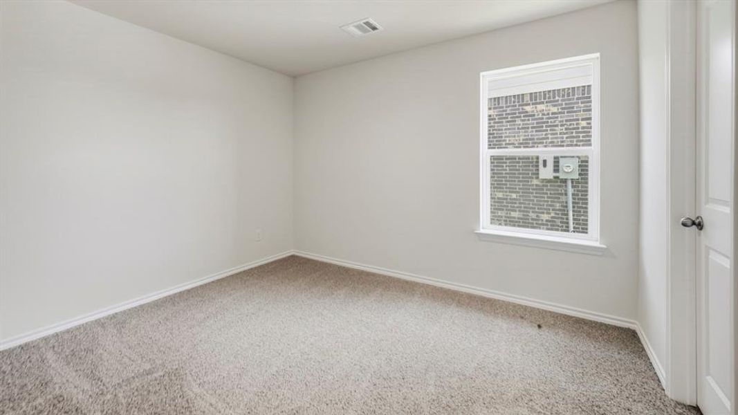 Carpeted spare room featuring baseboards